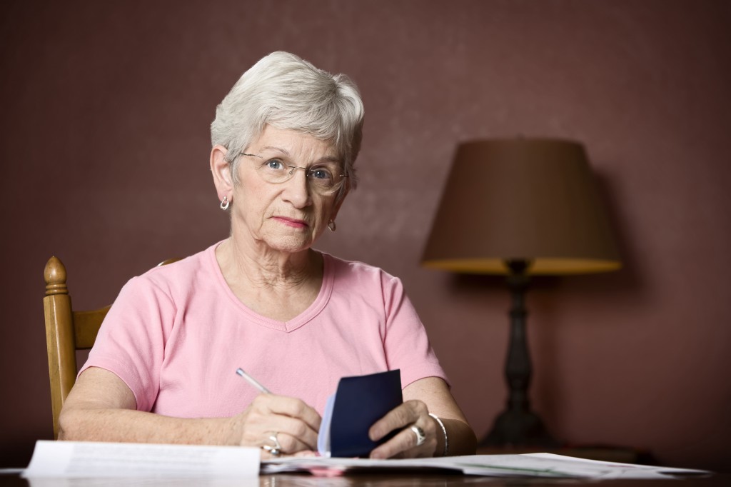 Senior woman paying bills